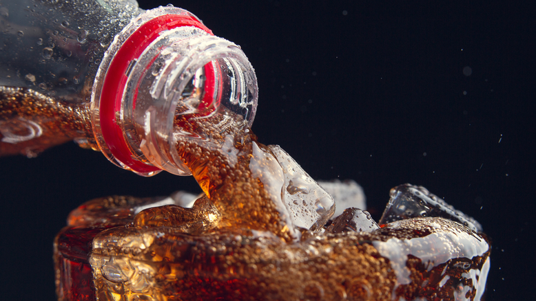Garrafa de Coca Cola sendo servida no copo