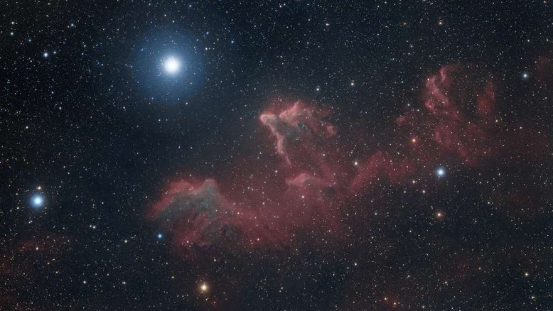 Essas formas fluidas e brilhantes parecem fantasmagóricas em uma escala cósmica. Esta visão telescópica do céu na direção da Constelação de Cassiopeia apresenta as nuvens IC 59 (esquerda) e IC 63 (direita). A cerca de 600 anos-luz de distância, elas estão desaparecendo lentamente, sob a influência da radiação energética da estrela quente e luminosa Gamma Cassiopeiae. Fisicamente localizada a 3 a 4 anos-luz de distância das nebulosas, Gamma Cassiopeiae é a estrela brilhante logo acima e à esquerda no quadro