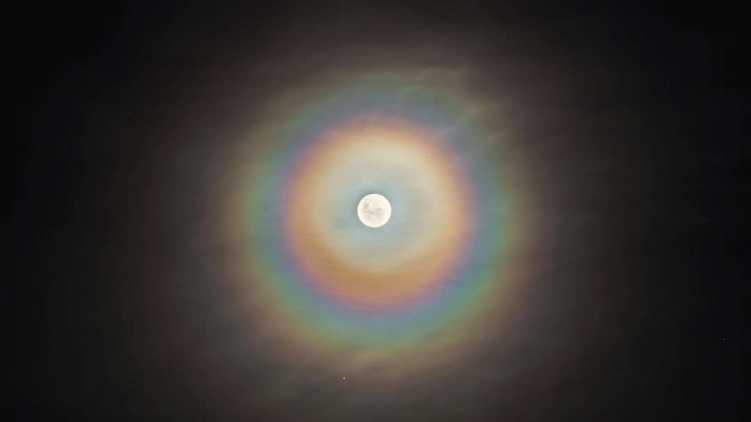 O que são estes anéis coloridos ao redor da Lua? Eles aparecem, às vezes, quando a Lua é vista através de nuvens finas. O efeito é criado pela difração quântica da luz em torno de gotículas de água. Como a luz de diferentes cores apresenta comprimentos de onda variados, cada cor difrata de maneira diferente. Chamado de coroa lunar, este é um dos poucos efeitos de cor da mecânica quântica que podem ser facilmente vistos a olho nu. Esta imagem de coroa lunar foi capturada em uma noite de Lua Cheia, em junho de 2015, em La Plata, na Argentina