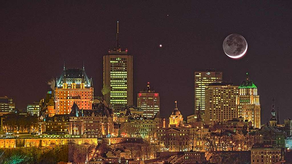 Este registo, feito em fevereiro de 2015, na cidade de Quebec, no Canadá, mostra a tripla conjunção da Lua, Vênus e Marte. Logo após o pôr do Sol, a Lua Nova mostra um leve crescente ao lado do brilhante planeta Vênus. Marte, um pouco mais fraco, está mais acima no quadro. A parte escura da Lua é iluminada apenas pela luz refletida da Terra, chamada de luz cinérea