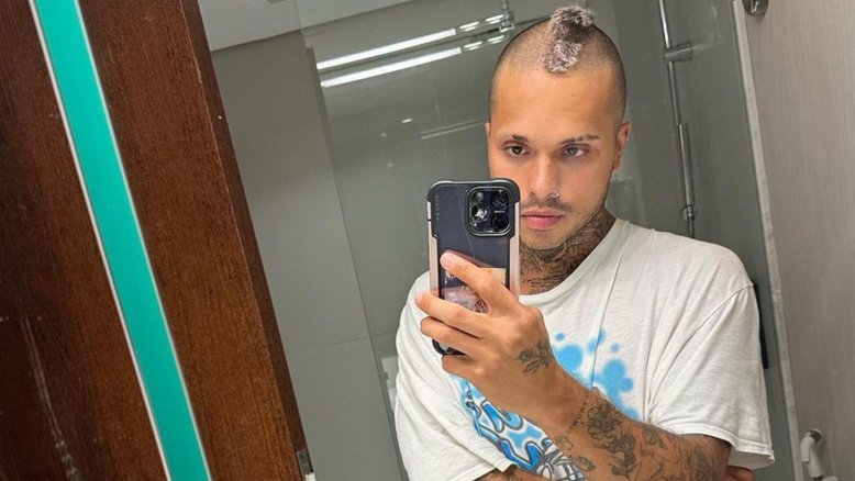 cantor vitão em frente a um espelho