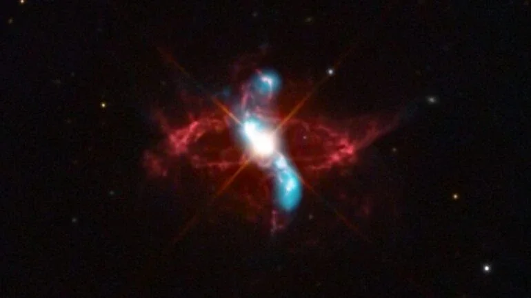 A estrela variável R Aquarii é, na verdade, um sistema estelar binário em interação, com duas estrelas que parecem ter uma relação simbiótica. A cerca de 710 anos-luz de distância, na Constelação de Aquário, ela consiste em uma estrela gigante vermelha fria e uma estrela anã branca quente e densa. Elas estão em órbita mútua, em torno de seu centro de massa comum. A luz visível do sistema binário é dominada pela gigante vermelha, mas o material no envelope estendido da estrela gigante fria é puxado pela gravidade para a superfície da anã branca, menor e mais densa, desencadeando uma explosão termonuclear que lança material para o espaço