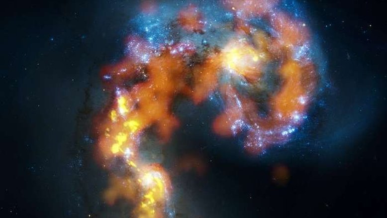 NGC 4038 e 4039 são um par de galáxias espirais distorcidas em colisão a cerca de 70 milhões de anos-luz de distância, na Constelação do Corvo. Esta visão combina observações do observatório ALMA, feitas em três faixas de comprimento de onda, com observações de luz visível do Telescópio Espacial Hubble. Enquanto a luz visível — mostrada aqui principalmente em azul — revela as estrelas recém-nascidas, os demais comprimentos de onda revelam nuvens de gás frio e denso a partir das quais novas estrelas se formam. Concentrações massivas de gás estão não apenas no coração das duas galáxias, mas também na região caótica onde elas estão colidindo. A quantidade total de gás é bilhões de vezes a massa do Sol