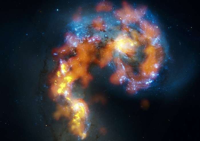 NGC 4038 e 4039 são um par de galáxias espirais distorcidas em colisão a cerca de 70 milhões de anos-luz de distância, na Constelação do Corvo. Esta visão combina observações do observatório ALMA, feitas em três faixas de comprimento de onda, com observações de luz visível do Telescópio Espacial Hubble. Enquanto a luz visível — mostrada aqui principalmente em azul — revela as estrelas recém-nascidas, os demais comprimentos de onda revelam nuvens de gás frio e denso a partir das quais novas estrelas se formam. Concentrações massivas de gás estão não apenas no coração das duas galáxias, mas também na região caótica onde elas estão colidindo. A quantidade total de gás é bilhões de vezes a massa do Sol