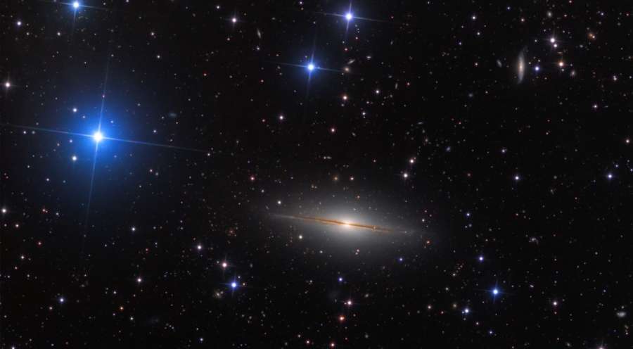 Na Constelação do Pégaso, vê-se esta extensão de estrelas da Via Láctea junto a algumas galáxias distantes. No centro, está NGC 7814, às vezes chamada de Pequeno Sombrero por sua semelhança com a mais brilhante e famosa M104, a Galáxia do Sombrero. Ambas são galáxias espirais vistas de lado, com extensos bulbos centrais cortados por um disco mais fino com faixas de poeira em silhueta. NGC 7814 está a cerca de 40 milhões de anos-luz de distância e tem um diâmetro estimado de 60 mil anos-luz. Isso faz com que a Galáxia do Pequeno Sombrero tenha aproximadamente o mesmo tamanho físico de sua homônima mais conhecida, parecendo menor e mais fraca apenas porque está mais distante