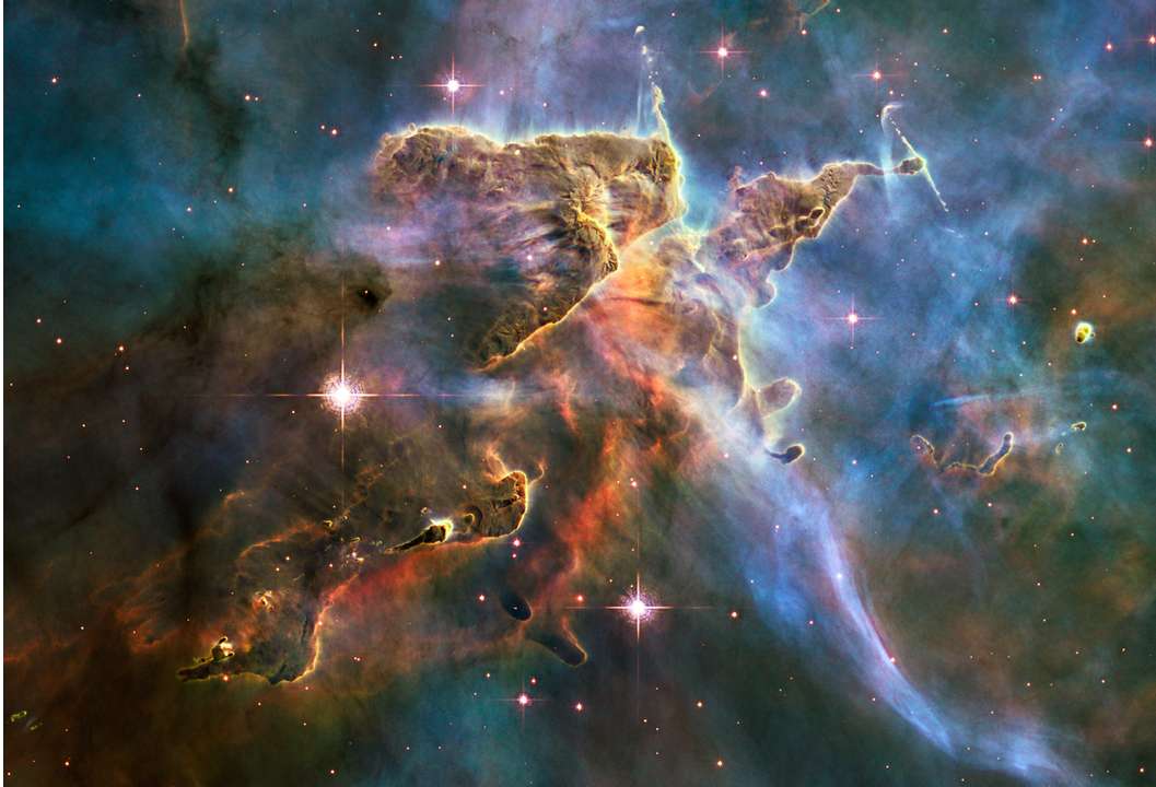 Nesta imagem do Telescópio Espacial Hubble, vê-se esta nuvem ondulante de gás interestelar frio e poeira de um berçário estelar da Nebulosa de Carina, a 7,5 mil anos-luz de distância, na Constelação de Carina. Este pilar de poeira e gás serve como uma incubadora para novas estrelas e está repleto de atividades de formação estelar. Estrelas quentes e jovens erodem e esculpem as nuvens nesta paisagem, enviando ventos estelares espessos e radiação ultravioleta escaldante. O par de jatos retratado, HH 901 e HH 902, representa uma assinatura comum do nascimento de novas estrelas