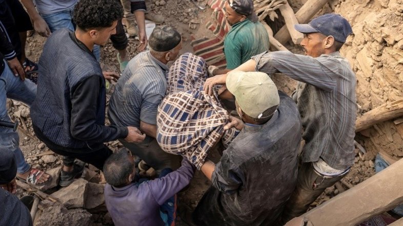Socorristas recuperam corpo entre os escombros de casa destruída após terremoto em Imi N'Tala, centro do Marrocos - AFP