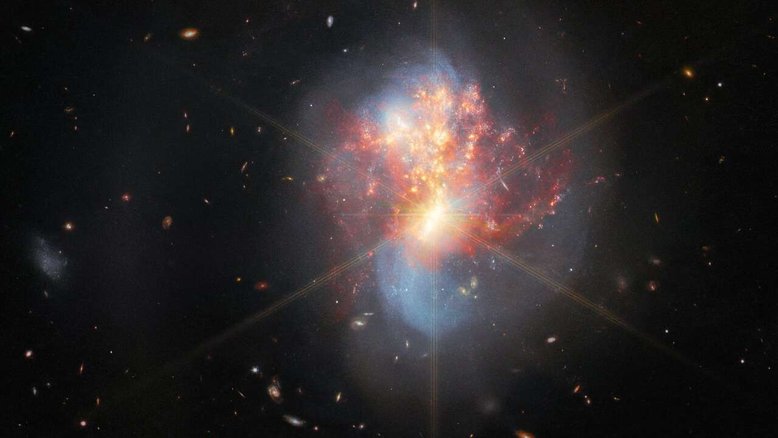 Este registro do Telescópio Espacial James Webb mostra IC 1623, um par de galáxias em interação, que fica a cerca de 270 milhões de anos-luz da Terra, na Constelação de Cetus. As duas galáxias em IC 1623 estão mergulhando de cabeça uma na outra, em um processo de fusão. A sua colisão desencadeou uma onda frenética de formação estelar, criando novas estrelas a uma taxa mais de vinte vezes superior à da Via Láctea. O núcleo luminoso da fusão de galáxias é tão brilhante e compacto que os picos de difração do Webb aparecem no topo da imagem