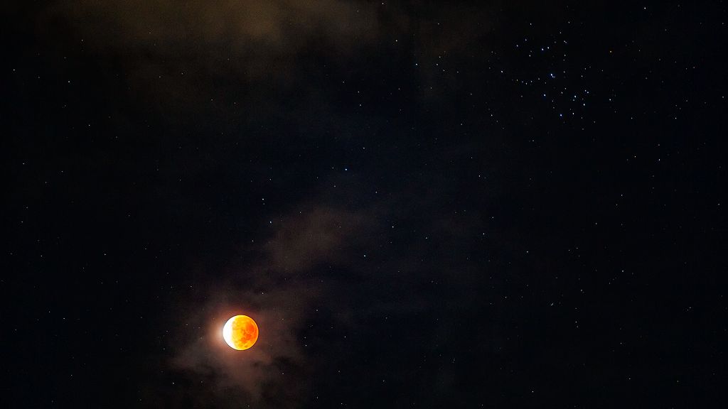 Esta imagem foi feita durante o Eclipse Lunar Parcial, que aconteceu em 19 de novembro de 2021, em Cancún, no México. Nela, vê-se que o disco lunar não está totalmente imerso na sombra umbral escura da Terra. Nesta madrugada, o eclipse parcial foi profundo o suficiente para mostrar a luz fraca, mas avermelhada, na sombra da Terra. Essa é uma visão frequentemente esperada pelos fãs dos eclipses lunares totais. A luz mais fraca da Lua eclipsada também tornou mais fácil localizar as estrelas no seu entorno