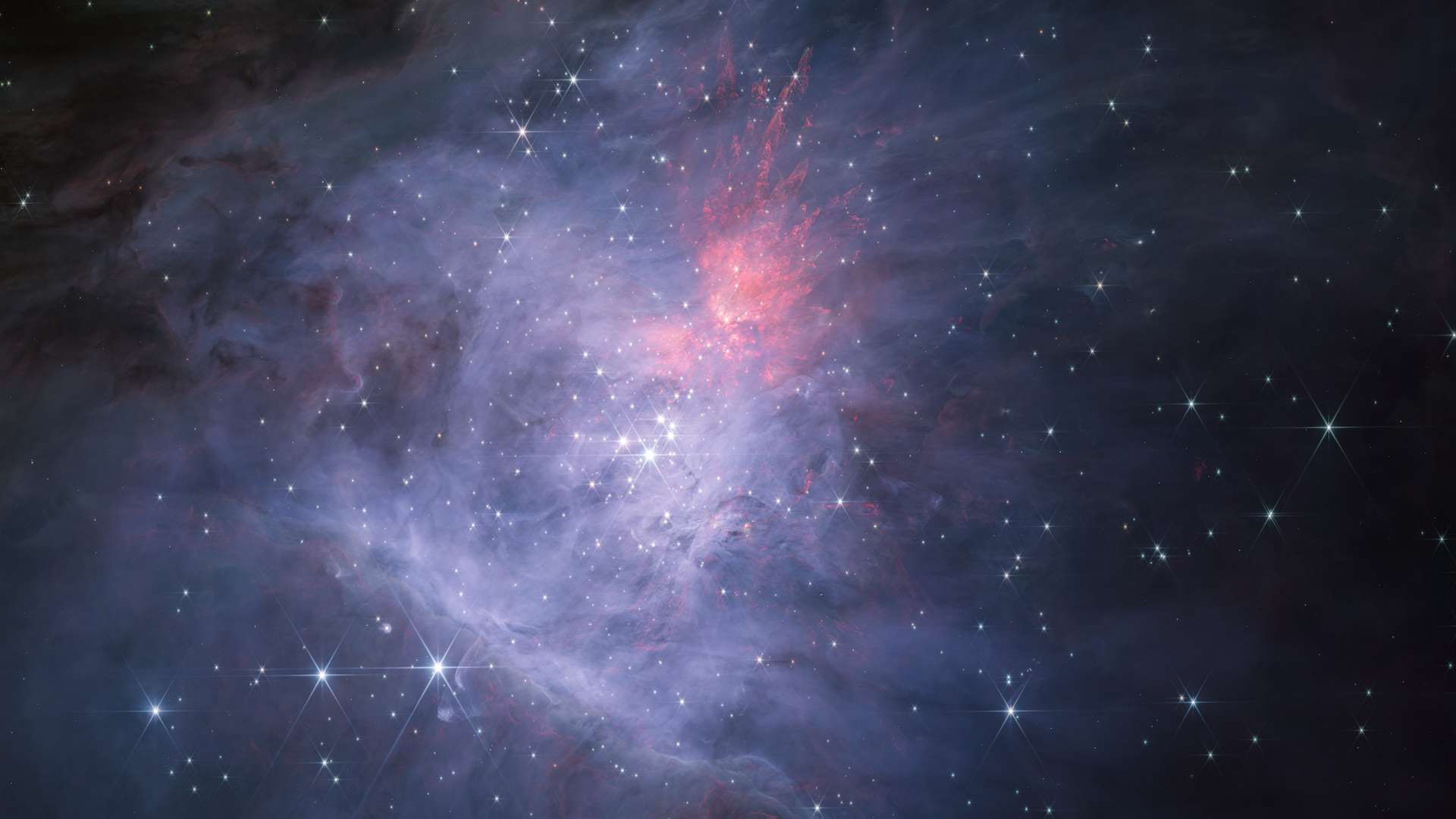Esta imagem, feita pelo Telescópio Espacial James Webb, mostra a Nebulosa de Órion e o Aglomerado do Trapézio. Esta composição colorida em comprimento de onda curto revela a nebulosa, suas estrelas e muitos outros objetos com detalhes sem precedentes no infravermelho. Esta jovem região de formação estelar tem apenas um milhão de anos e contém milhares de novas estrelas. A Nebulosa de Órion fica a cerca de 1,3 mil anos-luz da Terra, na direção da Constelação de Órion