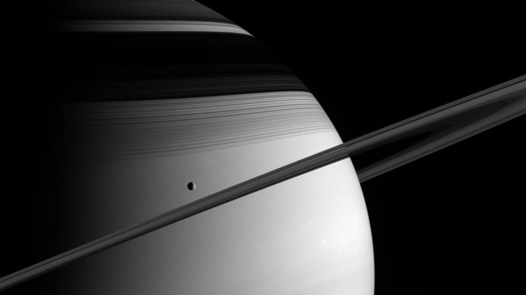 Nesta imagem, vê-se a lua saturnina Tétis, registrada pela espaçonave Cassini. Capturada pela luz solar, logo abaixo e à esquerda do centro da imagem, em 2005, Tétis tem cerca de mil quilômetros de diâmetro. Tétis é uma das cinco principais luas que se encontram dentro dos limites do fraco e tênue anel E exterior de Saturno. Descobertas na década de 1980, duas luas muito pequenas, Telesto e Calipso, estão estáveis ​​ao longo da órbita de Tétis. Telesto precede e Calipso e segue Tétis, enquanto o trio circunda Saturno