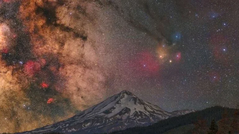O céu está em fúria com o Monte Shasta? De acordo com algumas lendas antigas, os espíritos lutam lá, de forma bastante ativa durante as erupções deste enorme vulcão na Califórnia, EUA. Tal drama pode muito bem ser imaginado nesta imagem, feita em junho de 2022. Acima do pico coberto de neve está a faixa central da Via Láctea, à esquerda. As cores da Constelação de Escorpião e da Constelação de Serpentário estão à direita, onde a brilhante estrela laranja Antares e o colorido complexo de nuvens Rho Ophiuchi estão destacados. Em alguns milhões de anos, Antares, algumas estrelas do sistema Rho Ophiuchi e Zeta Ophiuchi provavelmente explodirão em supernovas