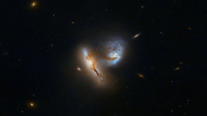 O par de objetos luminescentes desta imagem representam galáxias com milhões e milhões de estrelas. Esta dupla é conhecida como UGC 2369. As galáxias estão interagindo, o que significa que a atração gravitacional mútua as aproxima cada vez mais e distorce as suas formas no processo. Uma ponte tênue de gás, poeira e estrelas pode ser vista entre as duas galáxias, pela qual elas puxaram material uma da outra, tornando sua divisão cada vez menor. Esse tipo de interação é um evento comum na história da maioria das galáxias. UGC 2369 está a cerca de 424 milhões de anos-luz de distância, na direção da Constelação de Áries