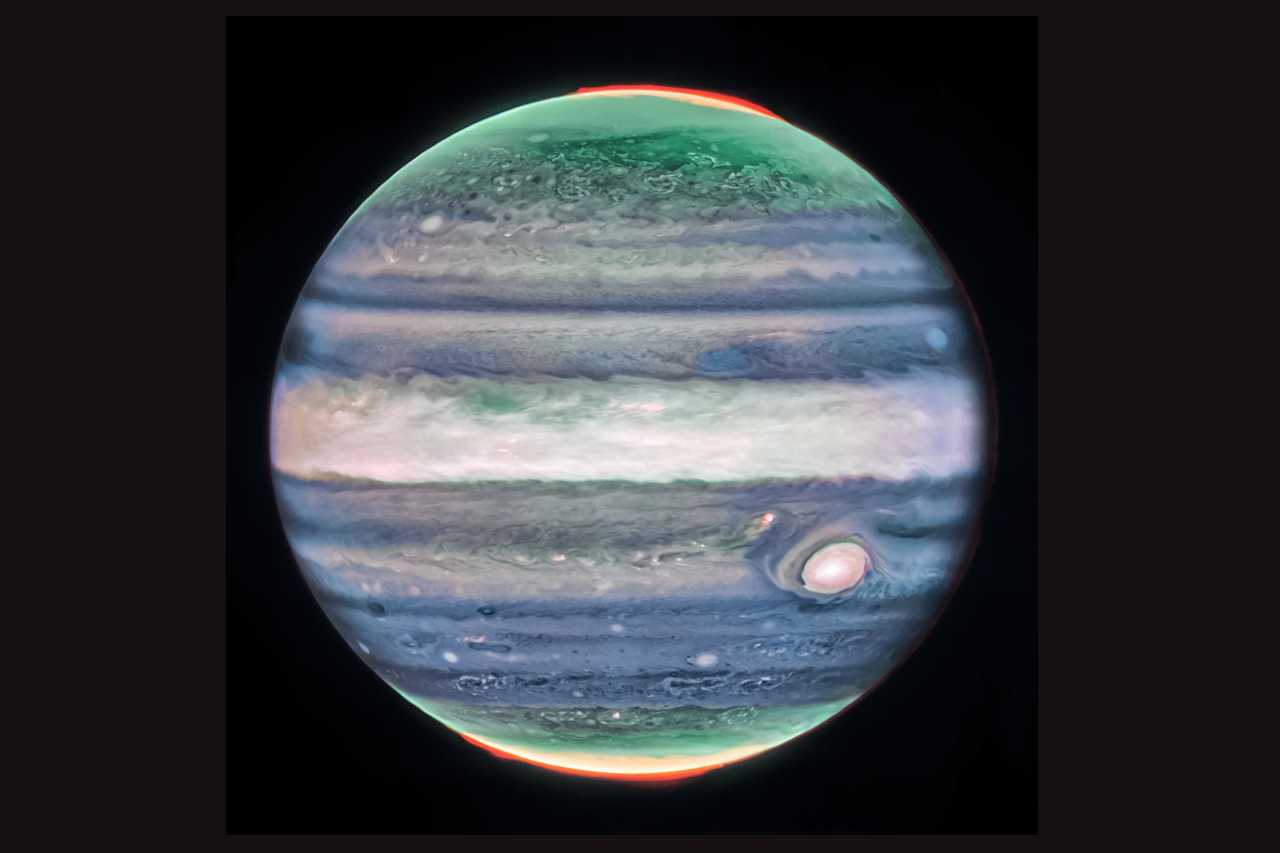 O Telescópio Espacial James Webb descobriu uma característica nova na atmosfera de Júpiter. Trata-se de uma corrente de jato de alta velocidade, que se estende por mais de 4,8 mil quilômetros de largura e fica sobre o equador do planeta, acima das principais plataformas de nuvens. Nesta imagem, em luz infravermelha, o brilho indica altitude elevada. As manchas e faixas brancas são provavelmente topos de nuvens de tempestades convectivas condensadas. As auroras, que aparecem em vermelho, estendem-se acima dos Pólos Norte e Sul do planeta
