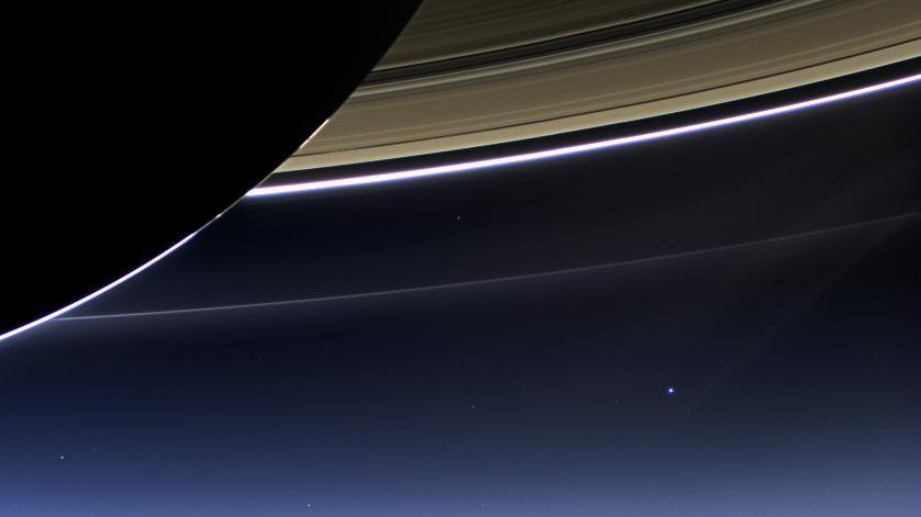 Nesta rara imagem, feita em julho de 2013, a câmera da espaçonave Cassini capturou os anéis de Saturno, a Terra e Lua no mesmo quadro. O lado escuro de Saturno, sua borda brilhante, e alguns de seus anéis principais são claramente vistos. As aparentes quebras no brilho da borda de Saturno acontecem em função das sombras dos anéis no globo, impedindo que a luz solar brilhe através da atmosfera nessas regiões. A Terra, que está a 1,44 bilhão de quilômetros de distância, aparece como um ponto azul, no centro à direita, e a Lua pode ser vista como uma protuberância mais fraca, mais à direita. Os outros pontos brilhantes próximos são estrelas