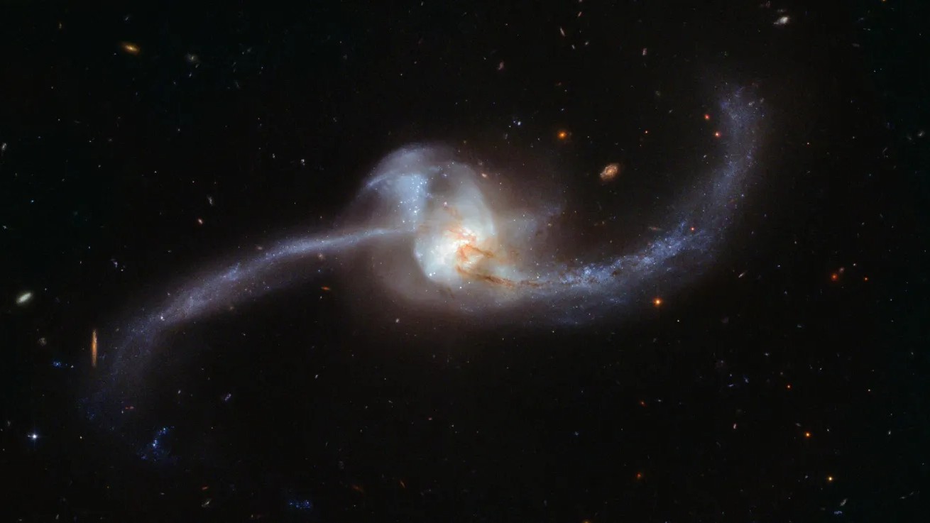 Esta imagem, capturada pelo Telescópio Espacial Hubble da NASA/ESA, mostra o que acontece quando duas galáxias se tornam uma. O nó cósmico torcido visto aqui é NGC 2623 — ou Arp 243 — e está localizado a cerca de 250 milhões de anos-luz de distância, na Constelação de Câncer. NGC 2623 ganhou a sua forma incomum e distinta como resultado de uma grande colisão e subsequente fusão entre duas galáxias separadas