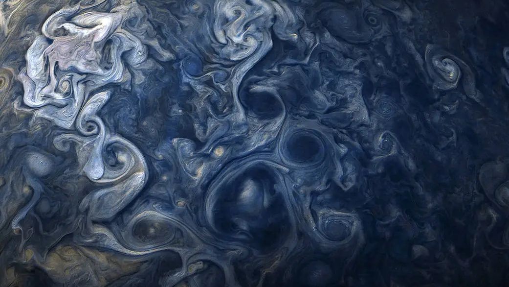 As nuvens jupiterianas aparecem em impressionantes tons de azul nesta imagem feita pela sonda Juno, da Nasa. A sonda Juno capturou este registro quando estava a apenas a cerca de 19 mil km do topo das nuvens de Júpiter, ou seja, a aproximadamente a mesma distância entre a cidade de Nova Iorque, nos EUA, a Perth, na Austrália. A imagem colorida, que destaca um sistema de nuvens no Hemisfério Norte de Júpiter, foi feita em outubro de 2017. Devido ao ângulo da espaçonave em relação a Júpiter e ao Sol, as nuvens de maior altitude podem ser vistas lançando sombras nos seus arredores