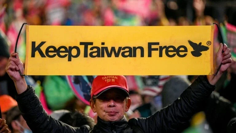 Simpatizante de Lai Ching-te mostra um cartaz com o slogan "Mantenham Taiwan livre", durante comício do candidato em Taipei, em 11 de janeiro de 2024 - AFP