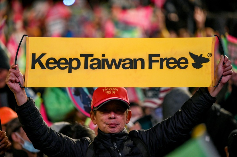 Simpatizante de Lai Ching-te mostra um cartaz com o slogan "Mantenham Taiwan livre", durante comício do candidato em Taipei, em 11 de janeiro de 2024 - AFP