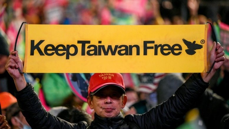 Simpatizante de Lai Ching-te mostra um cartaz com o slogan "Mantenham Taiwan livre", durante comício do candidato em Taipei, em 11 de janeiro de 2024 - AFP