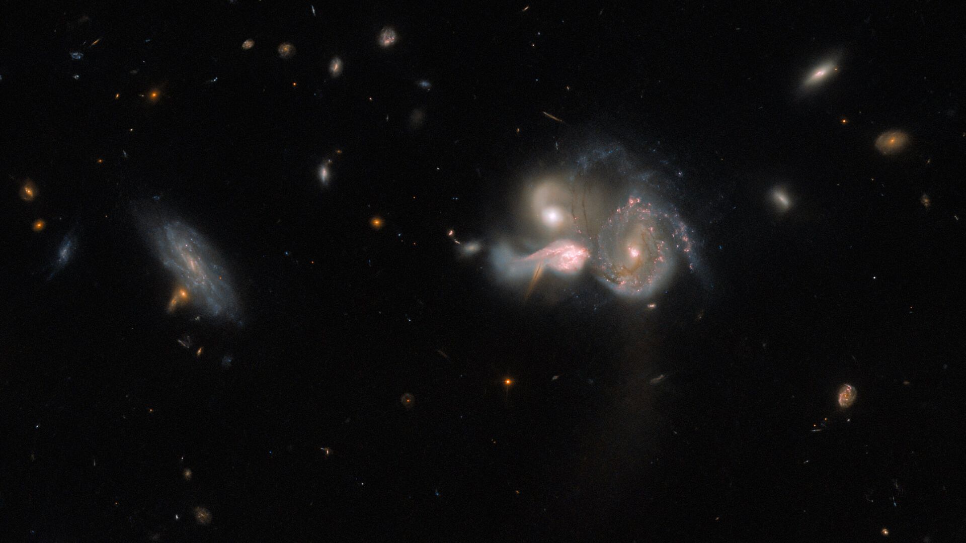 Este trio de galáxias está localizado na Constelação de Bootes (“O Boieiro”), em rota de colisão. Elas acabarão por se fundir numa galáxia maior, distorcendo as estruturas em espiral por meio da interação gravitacional. Conhecido por SDSSCGB 10189, o trio é uma combinação relativamente rara, já que as galáxias estão a apenas 50 mil anos-luz uma da outra. Embora possa parecer uma distância avantajada, pode-se dizer que elas estão extremamente próximas. Para se ter uma ideia, Andrômeda, a galáxia mais próxima da nossa Via Láctea, está a mais de 2,5 milhões de anos-luz de distância