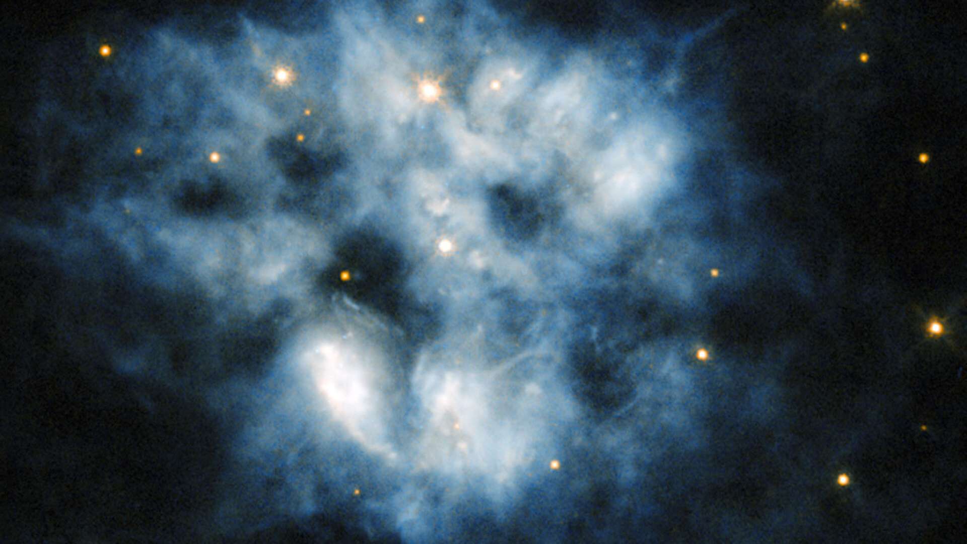 Esta imagem do Telescópio Espacial Hubble mostra a nebulosa planetária NGC 2452, localizada na Constelação de Puppis (“A Popa”). A névoa azul na moldura é o que resta de uma estrela como o nosso Sol, depois de esgotar todo o seu combustível. Quando isto acontece, o núcleo da estrela torna-se instável e libera um grande número de partículas incrivelmente energéticas que espalham a atmosfera da estrela para o espaço. No centro desta nuvem azul está o que resta da estrela. Fria, fraca e extremamente densa, ela é uma anã branca pulsante, o que significa que o seu brilho varia ao longo do tempo e à medida que a gravidade provoca ondas que pulsam por todo o corpo da pequena estrela