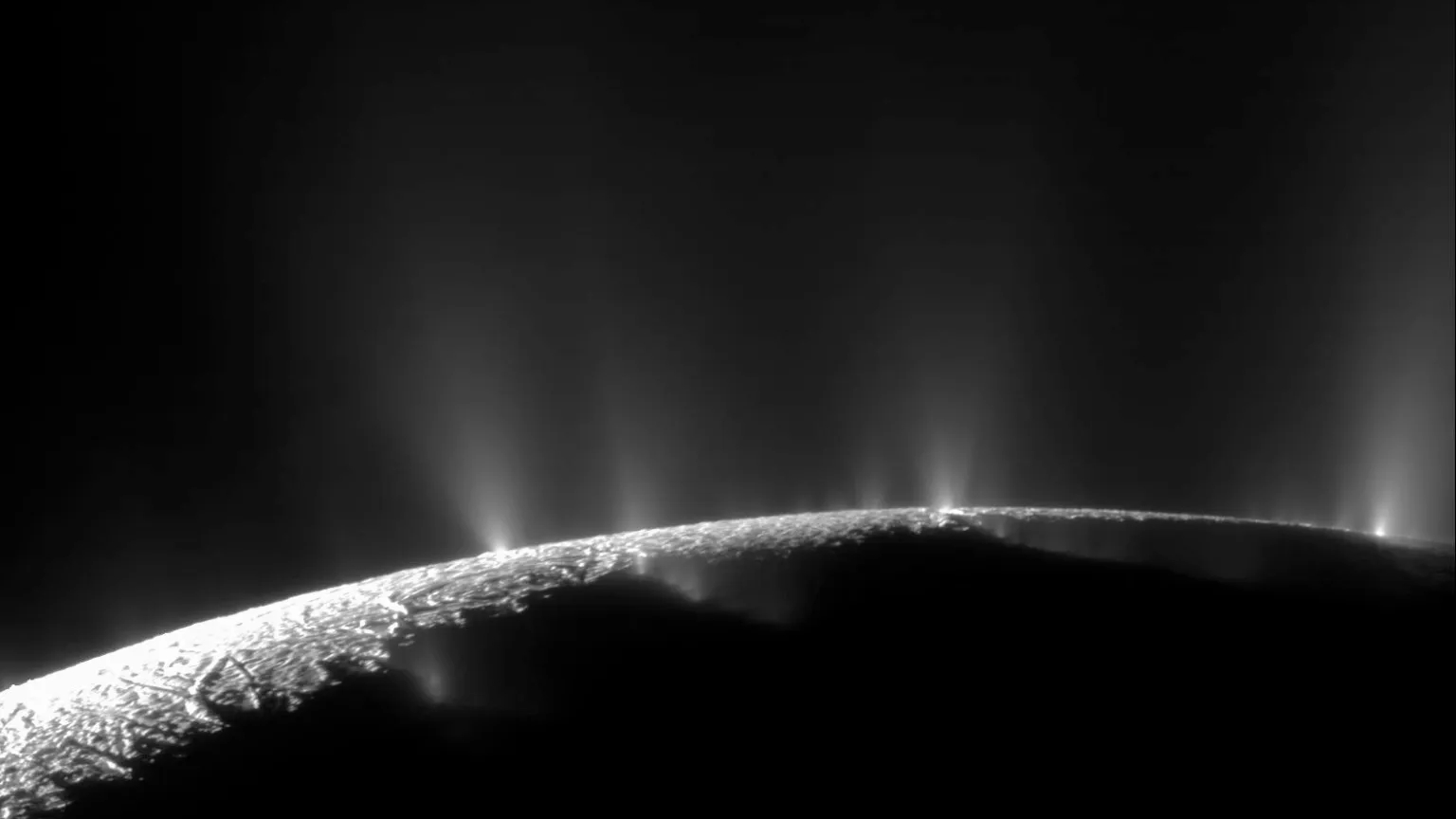 Plumas dramáticas, grandes e pequenas, borrifam água gelada e vapor de muitos locais ao longo das famosas “listras de tigre” perto do pólo sul da lua de Saturno, Encélado. As “listras de tigre” são quatro fraturas proeminentes, com aproximadamente 135 quilômetros de comprimento, que cruzam o terreno polar sul da lua. Este mosaico de duas imagens é uma dos registros de maior resolução obtidos pela sonda Cassini, durante o seu levantamento de imagens da bacia de gêiseres que cobre o hemisfério sul da lua de Saturno, Encélado