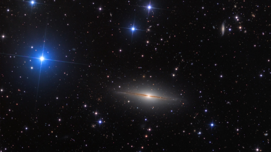 Na direção da Constelação do Pégaso, encontra-se esta extensão de estrelas da Via Láctea e galáxias distantes. No centro, vê-se NGC 7814, também chamada de Pequeno Sombrero por conta da sua semelhança com a mais brilhante e famosa M104, a Galáxia do Sombrero. Ambas são galáxias espirais vistas de lado, com extensos bulbos centrais cortadas pelo disco fino com faixas de poeira em silhueta. NGC 7814 está a cerca de 40 milhões de anos-luz de distância e tem um diâmetro estimado de 60 mil anos-luz. Isso faz com que a Galáxia do Pequeno Sombrero tenha aproximadamente o mesmo tamanho físico de seu homônimo mais conhecido, parecendo menor apenas porque está mais distante