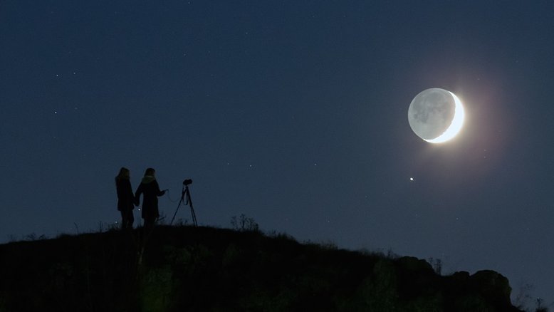 Nesta noite de Lua Nova, a sua fatia iluminada pelo Sol pairava perto do horizonte Oeste, próximo ao horário do pôr do Sol. Saturno brilhou no céu no início da noite, formando uma bela conjunção visível para os observadores em solo terrestre. Na imagem, registrada em uma colina perto de Veszprem, na Hungria, uma mãe na companhia da filha compõem a paisagem dominada pelo planeta brilhante e a jovem Lua