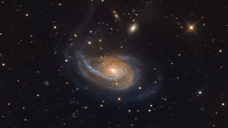 A peculiar galáxia espiral Arp 78 pode ser localizada na direção da Constelação de Áries e está a cerca de 100 milhões de anos-luz de distância. Também conhecida como NGC 772, ela tem mais de 100 mil anos-luz de diâmetro e ostenta um único braço espiral externo que pode ser visto nesta imagem. A sua galáxia companheira mais brilhante, a compacta NGC 770, está na parte superior direita da espiral maior. A aparência difusa e elíptica da NGC 770 contrasta bem com o registro de uma estrela pontiaguda, localizada na nossa Via Láctea, que está em primeiro plano, mais à direita, em tons amarelados