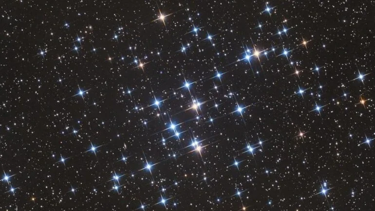 Localizado na Constelação de Câncer e a apenas 600 anos-luz de distância, M44 é um dos aglomerados estelares mais próximos do nosso Sistema Solar. Também conhecido como Aglomerado da Colmeia, suas estrelas são bem jovens, com aproximadamente 600 milhões de anos, quando comparadas aos mais de 4,5 bilhões de anos do nosso Sol. Como aglomerado aberto, que se estende por cerca de 15 anos-luz, M44 contém em média mil estrelas e é visível a olho nu, sendo reconhecido desde a Antiguidade. As poucas estrelas gigantes vermelhas, frias e de cor amarelada do aglomerado aparecem nesta imagem junto às suas diversas estrelas azuis, quentes e mais brilhantes
