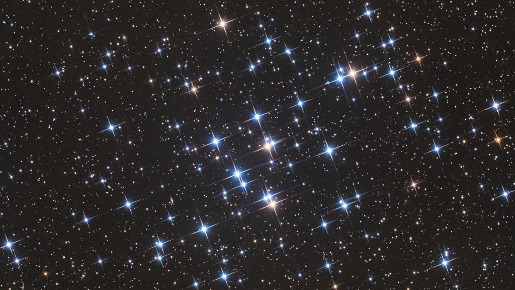 Localizado na Constelação de Câncer e a apenas 600 anos-luz de distância, M44 é um dos aglomerados estelares mais próximos do nosso Sistema Solar. Também conhecido como Aglomerado da Colmeia, suas estrelas são bem jovens, com aproximadamente 600 milhões de anos, quando comparadas aos mais de 4,5 bilhões de anos do nosso Sol. Como aglomerado aberto, que se estende por cerca de 15 anos-luz, M44 contém em média mil estrelas e é visível a olho nu, sendo reconhecido desde a Antiguidade. As poucas estrelas gigantes vermelhas, frias e de cor amarelada do aglomerado aparecem nesta imagem junto às suas diversas estrelas azuis, quentes e mais brilhantes