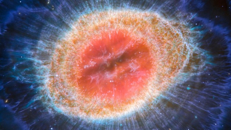 O Telescópio Espacial James Webb da Nasa/ESA/CSA observou a conhecida Nebulosa do Anel (M57 ou NGC 6720) com detalhes sem precedentes. Formada por uma estrela que se desprende de suas camadas externas à medida que fica sem combustível, esta nebulosa planetária fica a cerca de 2,5 mil anos-luz de distância, na direção da Constelação da Lira. Há cerca de 20 mil glóbulos densos na nebulosa, que são ricos em hidrogênio molecular. Em contraste, a região interna mostra gás muito quente. O invólucro principal contém um anel fino de emissão aprimorada de moléculas à base de carbono, conhecidas como hidrocarbonetos aromáticos policíclicos (PAHs)