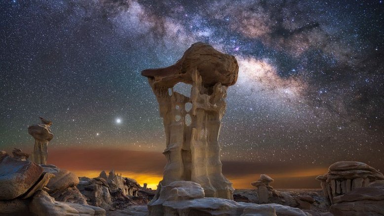 Que planetas estão atrás daquela torre rochosa incomum? Saturno (menor, mais abaixo e à esquerda) e Júpiter (mais brilhante e ligeiramente acima de seu par no Sistema Solar). A imagem foi feita em 2020, após o pôr do Sol, nas terras áridas da região selvagem de Ah-Shi-Sle-Pah, na Bacia de San Juan, no Novo México, EUA. Também são destaque neste registro a espetacular faixa central da nossa galáxia, a Via Láctea. A torre rochosa, informalmente apelidada de 'Trono Alienígena', tem cerca de 3 metros de altura
