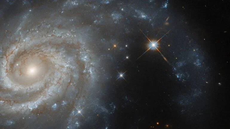 Esta imagem mostra a galáxia espiral IC 438, que fica a cerca de 130 milhões de anos-luz da Terra, na direção da Constelação de Lepus (“A Lebre”). Esse conjunto estelar é margeado pela Constelação do Cão Maior, pela Constelação de Órion e pela Constelação do Cão Menor. Isso faz com que, nas representações artísticas do céu, a lebre estelar seja representada como se estivesse sendo perseguida por Órion e seus dois cães de caça