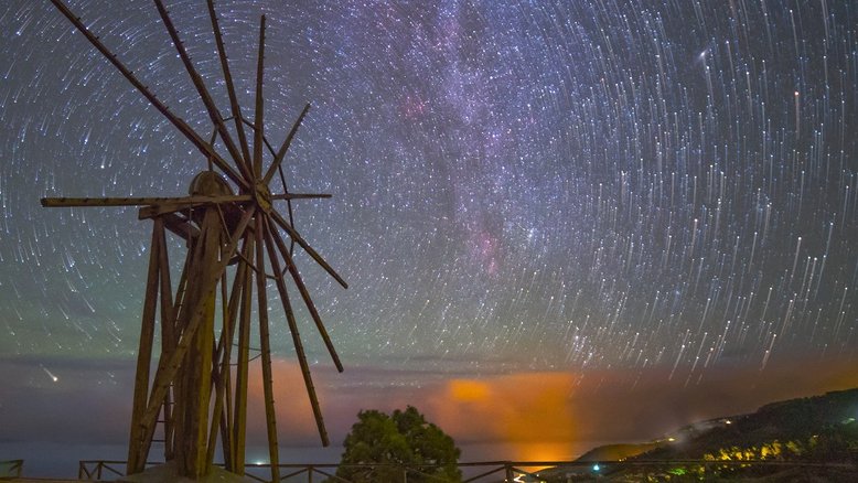 As estrelas não conseguem girar esses velhos braços de madeira, mas esta imagem dá essa impressão, como reflexo do nosso planeta estar em constante rotação. O registro da paisagem noturna foi feito em Garafía, um município da ilha de La Palma, nas Ilhas Canárias, Espanha. O centro do moinho de vento, que foi aposentado em 1953, está alinhado com o Polo Celeste Norte, o eixo de rotação da Terra projetado no céu. A partir de uma câmera fixada em um tripé, os rastros das estrelas resultam da rotação do planeta traçada em uma composição digital de 39 exposições sequenciais, com 25 segundos de duração cada uma. Realçadas pelo destaque da exposição final da sequência, as estrelas aparecem nas extremidades de seus curtos arcos concêntricos