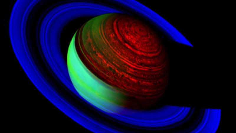 Nesta imagem da espaçonave robótica Cassini, obtida a cerca de 1,6 milhão de quilômetros de distância de Saturno, o gigante dos anéis é retratado em cores falsas, que resultam de três faixas de luz infravermelha. Na faixa mais azul, Saturno parece escuro, mas seus anéis finos refletem intensamente a luz do Sol. Por outro lado, o anel B de Saturno é tão espesso que pouca luz refletida consegue passar, criando uma faixa escura entre os anéis A e C. Na faixa mais vermelha, Saturno emite um brilho térmico surpreendentemente detalhado, indicando enormes tempestades, semelhantes a furacões e um estranho sistema de nuvens em forma de hexágono ao redor do Pólo Norte. Na faixa infravermelha média, de cor verde, o lado iluminado pelo Sol faz com que a atmosfera de Saturno reflita a luz intensamente