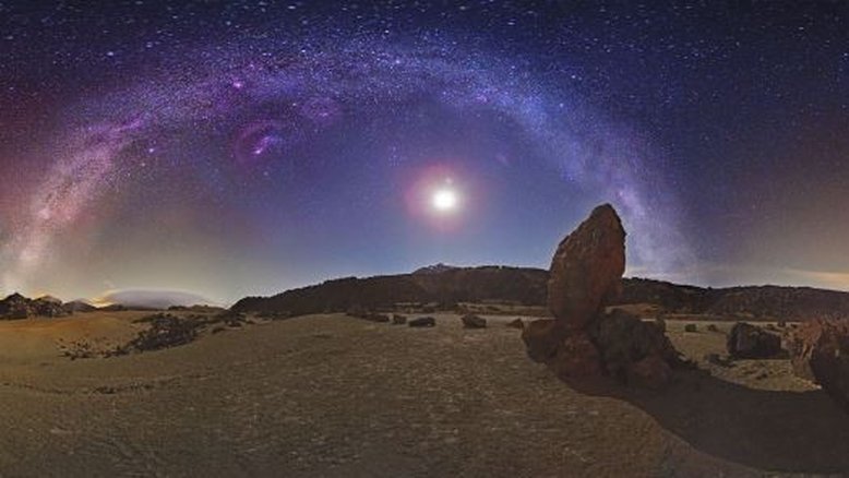Esta faixa brilhante no céu é um dos braços da nossa galáxia espiral, a Via Láctea. Como estamos dentro do disco galáctico, ela parece circundar a Terra. Esta imagem, registrada no Parque Nacional do Teide, em Tenerife, nas Ilhas Canárias (Espanha), inclui o vulcão Teide, visível perto do centro da imagem, adornado por maravilhas do céu visíveis a olho nu. Além da faixa da Via Láctea, a brilhante Lua Crescente está bem próxima ao aglomerado estelar aberto das Plêiades (M45), que aparece como um conjunto pontilhado cintilante, logo acima do nosso satélite natural