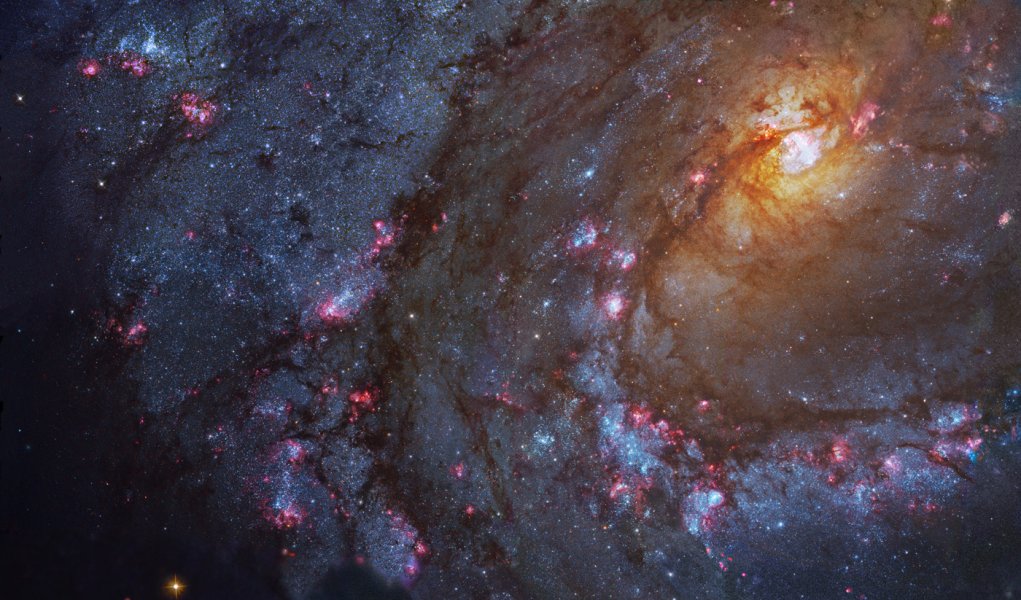 A grande, brilhante e bela galáxia espiral M83 fica a apenas doze milhões de anos-luz de distância, perto da ponta sudeste da Constelação da Hidra. Nesta imagem, vê-se a poeira escura e os jovens aglomerados de estrelas azuis ao longo dos braços espirais proeminentes que dão a M83 o apelido de Catavento do Sul. Normalmente encontradas perto das bordas das espessas faixas de poeira, as diversas regiões avermelhadas de formação de estrelas também dão outro apelido a M83: Galáxia dos Mil Rubis. Dominado pela luz de estrelas mais velhas, o seu núcleo amarelado brilhante fica no canto superior direito. Ele é rico em raios X, o que revela uma alta concentração de estrelas de nêutrons e buracos negros