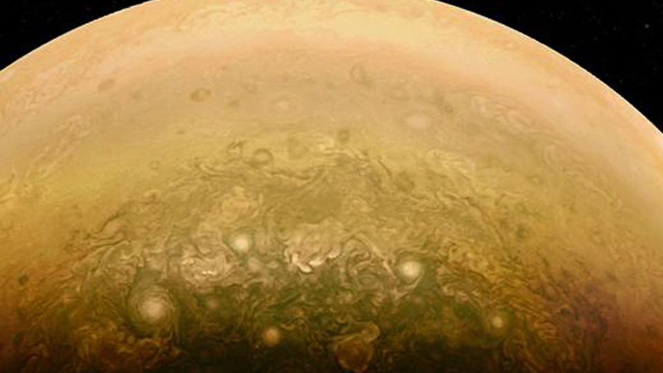 O que acontece no Pólo Sul de Júpiter? Nesta imagem da sonda robótica Juno, vê-se um interessante conglomerado de nuvens rodopiantes. Os ovais brancos foram observados em outros lugares do planeta e são considerados sistemas de tempestades gigantes. Eles duram anos e apresentam velocidades de vento de cerca de 350 quilômetros por hora. Ao contrário dos ciclones e furacões terrestres, onde ventos fortes circundam regiões de baixa pressão, as formas ovais brancas em Júpiter mostram vórtices centrados em regiões de alta pressão