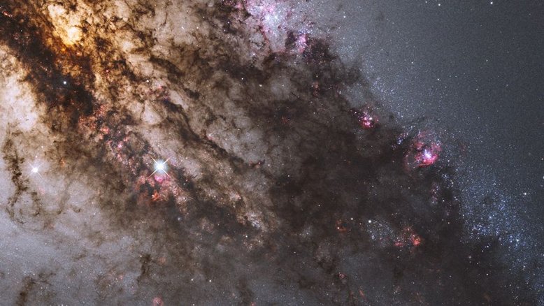 Jovens aglomerados de estrelas azuis, gigantescas nuvens de gás brilhante e imponentes faixas de poeira escura circundam a região central da galáxia ativa Centaurus A. Esta imagem do Telescópio Espacial Hubble foi processada para apresentar uma imagem em cores naturais deste turbilhão cósmico. No centro dessa atividade, estão o que parecem ser discos de matéria espiralando em direção a um buraco negro com um bilhão de vezes a massa do Sol. Centaurus A é aparentemente o resultado de uma colisão de duas galáxias e os detritos que sobraram estão sendo constantemente consumidos pelo buraco negro. Centaurus A está a apenas 10 milhões de anos-luz de distância, na direção da Constelação do Centauro