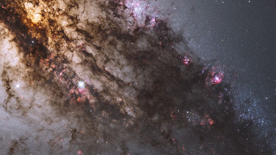 Jovens aglomerados de estrelas azuis, gigantescas nuvens de gás brilhante e imponentes faixas de poeira escura circundam a região central da galáxia ativa Centaurus A. Esta imagem do Telescópio Espacial Hubble foi processada para apresentar uma imagem em cores naturais deste turbilhão cósmico. No centro dessa atividade, estão o que parecem ser discos de matéria espiralando em direção a um buraco negro com um bilhão de vezes a massa do Sol. Centaurus A é aparentemente o resultado de uma colisão de duas galáxias e os detritos que sobraram estão sendo constantemente consumidos pelo buraco negro. Centaurus A está a apenas 10 milhões de anos-luz de distância, na direção da Constelação do Centauro