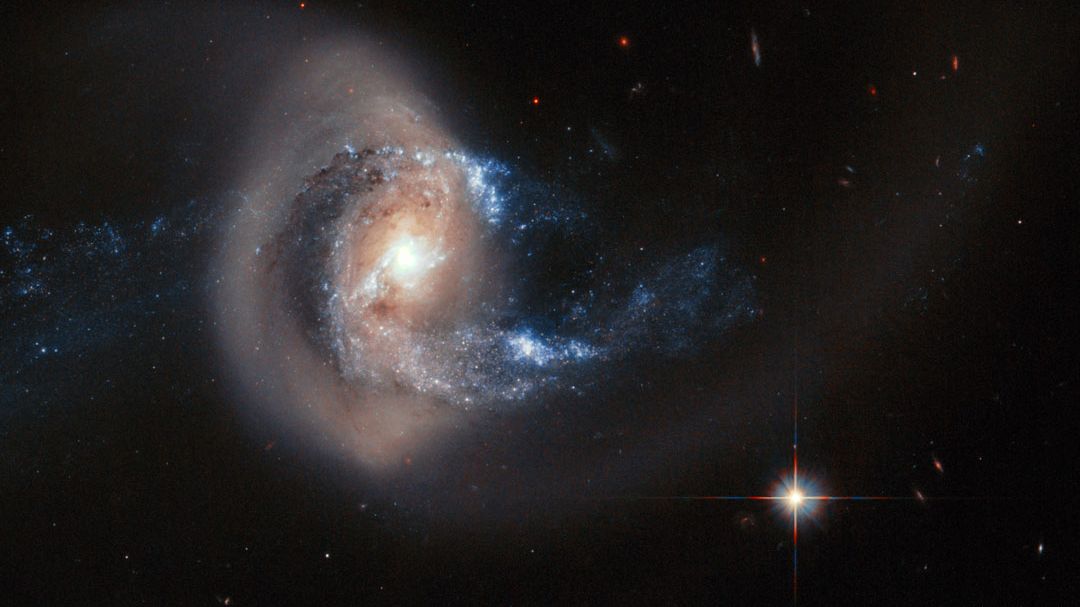 NGC 7714 é uma galáxia que foi esticada e distorcida por uma colisão recente com outra galáxia vizinha. Acredita-se que a vizinha menor, NGC 7715, situada à esquerda do quadro em destaque, tenha sido impactada por NGC 7714. As observações indicam que o anel dourado retratado é composto por milhões de estrelas mais antigas, semelhantes ao Sol, que provavelmente estão em movimento junto às estrelas interiores mais azuis. O centro brilhante da NGC 7714 também parece formar novas estrelas. NGC 7714 está localizada a cerca de 100 milhões de anos-luz de distância, na direção da Constelação de Peixes