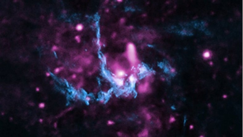 Esta imagem composta apresenta raios X (roxo) e dados de rádio (azul), na região de Sagitário A* (abreviadamente Sgr A*), o buraco negro supermassivo presente no centro da Via Láctea, a nossa galáxia. Nela, vê-se a localização de uma frente de choque, com jatos que se afastam de Sgr A* e viajam pelo espaço até atingir o gás a vários anos-luz de distância. Essa interação também acelera os elétrons, gerando raios X à medida que os elétrons percorrem o caminho do jato, passando pela frente de choque. Sgr A* tem cerca de 4 milhões de vezes a massa do Sol e fica a cerca de 26 mil anos-luz da Terra, na direção da Constelação de Sagitário