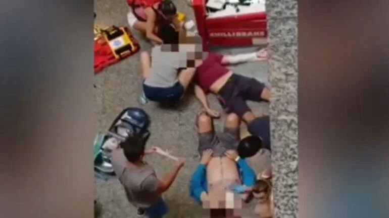 Homens feridos sendo socorridos no Shopping Miramar, em Santos (SP)
