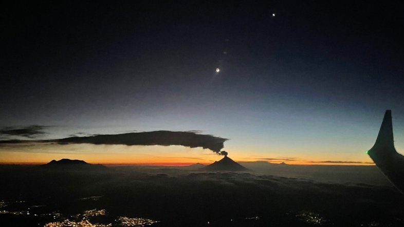 Atualmente, Vênus está aparecendo no céu antes do amanhecer, aqui na Terra, fazendo jus à sua alcunha de Estrela da Manhã. Nesta imagem, registrada a partir da janela de um vôo para a Cidade do México, o brilhante planeta foi capturado, pouco antes do nascer do Sol, em  setembro do ano passado. Vênus, no canto superior direito, compartilha o início do crepúsculo com a Lua Minguante, mais abaixo e à esquerda. Vistos nesta perspectiva estratosférica, os picos das montanhas e as nuvens aparecem como silhuetas ao longo do horizonte Leste. O longo e baixo banco de nuvens foi criado pela ventilação contínua do vulcão ativo Popocatepetl