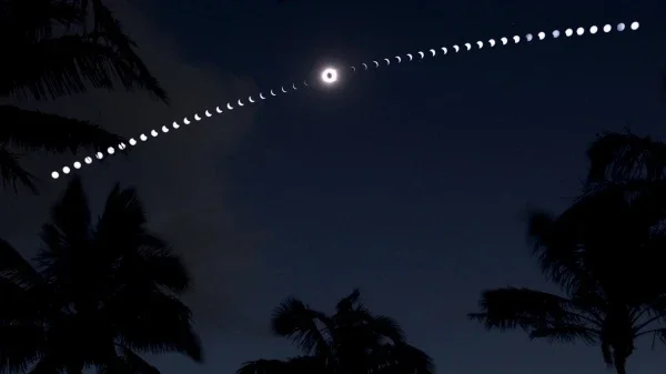 Enquanto a sombra da Lua Nova deslizava pelo Sul do Pacífico em 11 de julho de 2010, as pessoas se reuniram na praia de Anakena, no lado Norte da Ilha de Páscoa, para assistir ao Eclipse Solar Total. A experiência foi capturada nesta imagem composta, construída a partir de uma sequência de 50 exposições consecutivas. Ao centro, está o Sol totalmente eclipsado, rodeado pela coroa solar cintilante. As palmeiras aparecem em silhueta contra o céu escurecido e a tênue luz refletida na água. A Ilha de Páscoa - famosa pelas misteriosas estátuas Moai - recebeu este nome, pois foi descoberta pelo almirante holandês Jacob Roggeveen, no Domingo de Páscoa do ano de 1722
