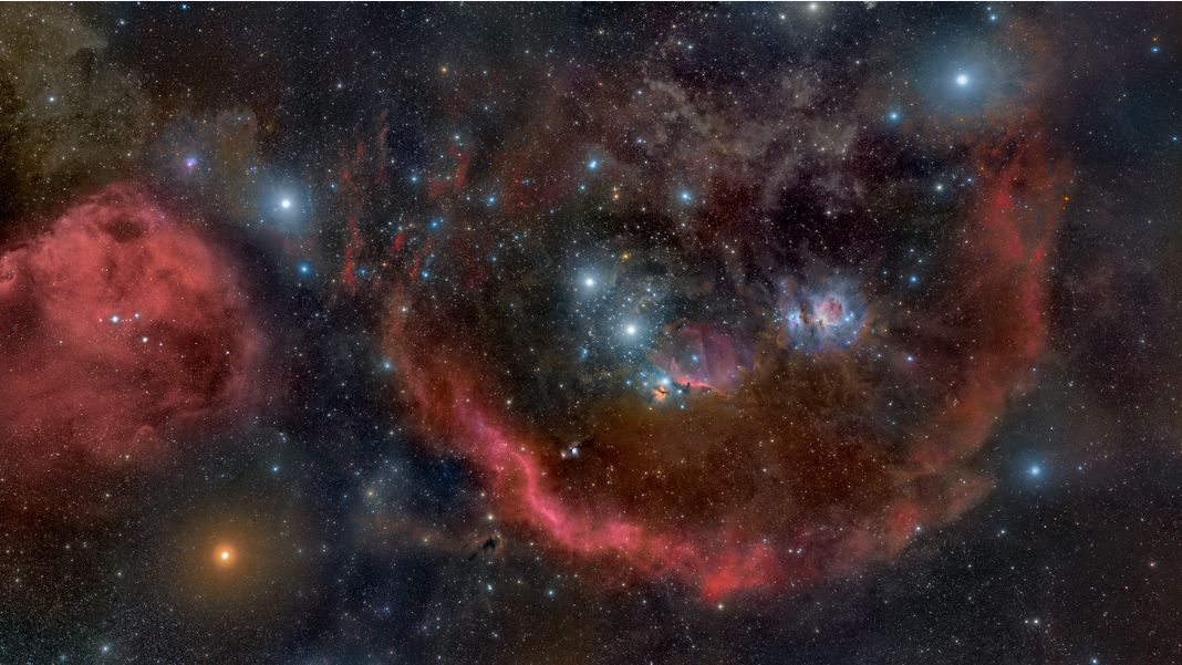Embalados em poeira cósmica e hidrogênio brilhante, os berçários estelares da Constelação de Órion ficam na borda de uma nuvem molecular gigante, a cerca de 1,5 mil anos-luz de distância. Abrangendo quase 25 graus, esta vista deslumbrante se estende pela conhecida constelação, da cabeça aos pés do caçador (da esquerda para a direita). A Grande Nebulosa de Órion, a região de formação estelar mais próxima, está à direita do centro. À sua esquerda, estão a Nebulosa Cabeça de Cavalo, a nebulosa difusa conhecida como M78 e as estrelas do Cinturão de Órion. A estrela gigante vermelha Betelgeuse, que marca o ombro do caçador, está abaixo e à esquerda, enquanto Rigel, a estrela azul brilhante que ilumina o seu pé, está no alto e à direita