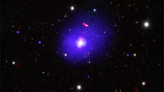 H1821+643 é um quasar alimentado por um buraco negro supermassivo, localizado a cerca de 3,4 bilhões de anos-luz da Terra, na direção da Constelação de Draco (“O Dragão”). A partir de suas observações, foi possível determinar a rotação de seu buraco negro, que tem entre três e 30 bilhões de massas solares, o que o torna um dos mais massivos conhecidos. A título de comparação, o buraco negro supermassivo no centro da Via Láctea tem cerca de quatro milhões de massas solares. Esta imagem composta de H1821+643 combina dados de raios X (azul), rádio (vermelho) e luz óptica (branco e amarelo)