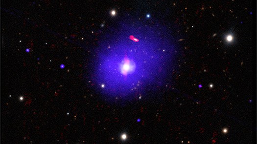 H1821+643 é um quasar alimentado por um buraco negro supermassivo, localizado a cerca de 3,4 bilhões de anos-luz da Terra, na direção da Constelação de Draco (“O Dragão”). A partir de suas observações, foi possível determinar a rotação de seu buraco negro, que tem entre três e 30 bilhões de massas solares, o que o torna um dos mais massivos conhecidos. A título de comparação, o buraco negro supermassivo no centro da Via Láctea tem cerca de quatro milhões de massas solares. Esta imagem composta de H1821+643 combina dados de raios X (azul), rádio (vermelho) e luz óptica (branco e amarelo)
